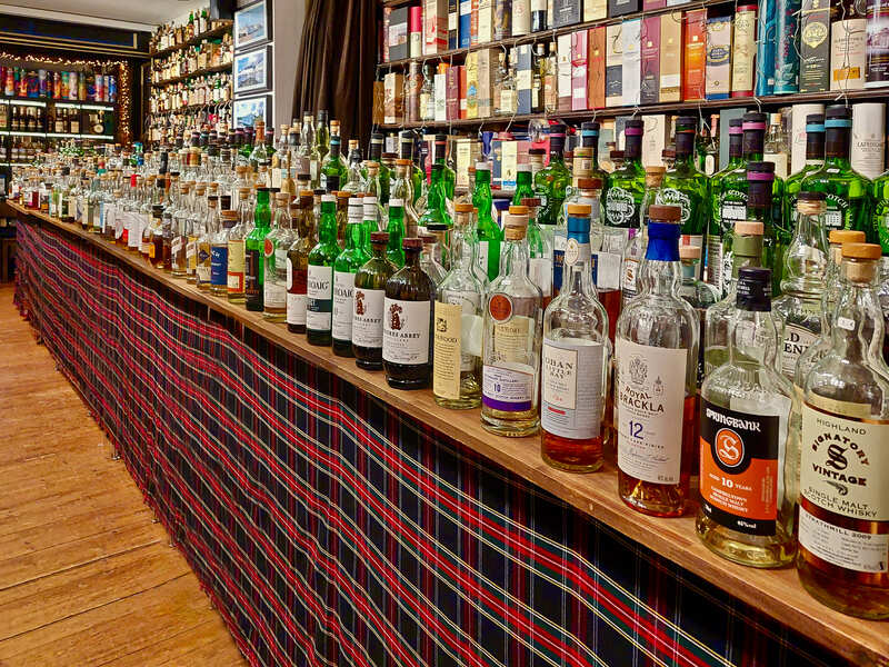 über 300 offener Whiskyflaschen auf langer Theke