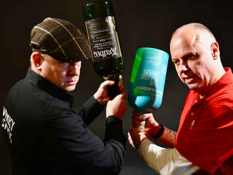 Haslinger und Jerger drohend mit jeweils einer 4,5 Liter Whiskyflasche