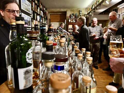 viele Leute vor vielen offene Whisky Flaschen