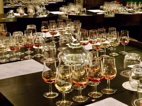 viele befüllte Whiskygläser auf mehreren Tischen verteilt