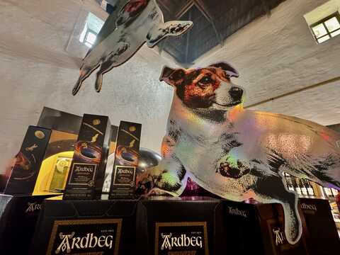 Im Ardbeg Restaurant, liegende Hund-Shortie-Pappe, über Smokiverse Flaschen